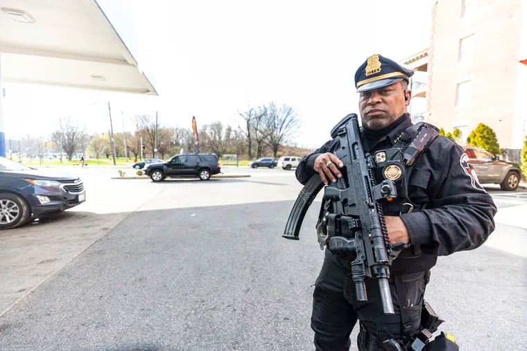 Andre Boyer, owner of Pennsylvania S.I.T.E. State Agents, stands guard at a Sunoco gas station in Strawberry Mansion. Boyer was denied a gun license and a private detective agency license in Philadelphia, but has a state armed guard certification.