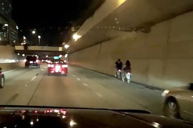 A video captured by a driver's dashcam shows two people using Indego, the city's bike-sharing system, heading westbound on Interstate 676 around 10 p.m.