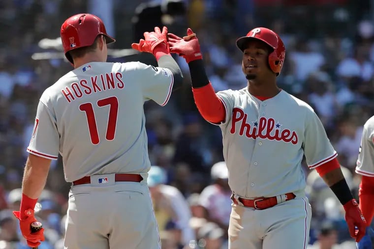 Shortstop Jean Segura celebrates with first baseman Rhys Hoskins after hitting a two-run homer in the fourth inning of the Phillies' 9-7 win against the Cubs on Thursday.