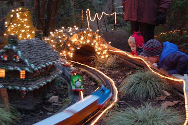 Jimmy Reath (left), Hooper Murphy take in 's Holiday Garden Railway, which lights up this Friday and next. Morris Arboretum