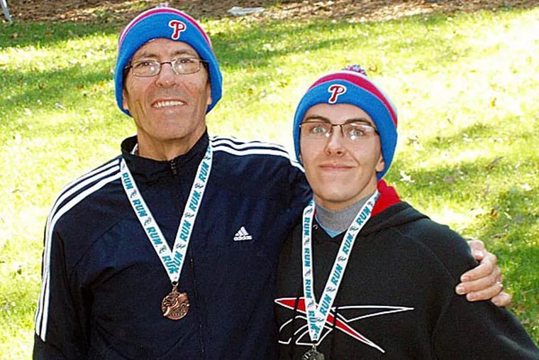 Chris and Andrew Kessler, father and son, show off their medals after a recent 5k race. Andrew, who is autistic, will be running his first Broad Street Run.