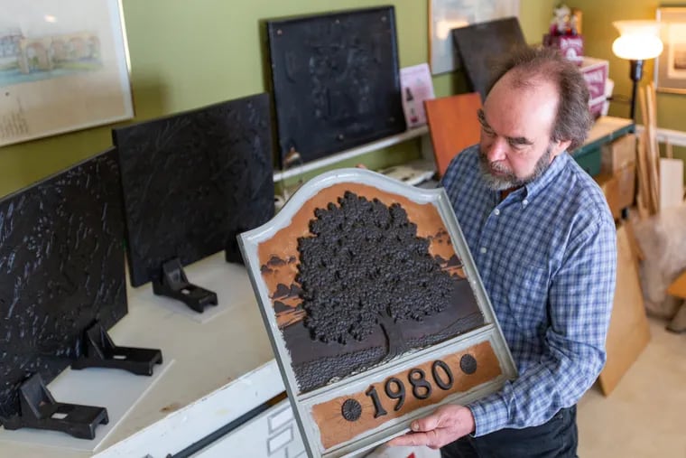 J. Del Conner holds a mold of his most popular fireback design, "The Great Oak," at his home, which doubles as a studio, in Hamburg, Berks County. Conner makes original firebacks, decorative pieces for fireplaces, and claims they are being pirated in China.