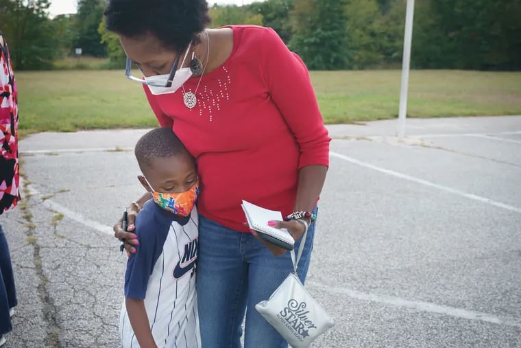 Inquirer reporter Melanie Burney receives a hug from Devon on the playground during recess, at the Paulsboro Boys & Girls Club in Paulsboro, NJ, on October 2, 2020. In Paulsboro, about 25 students come to the Boys and Girls center from 8 am. To 5 p.m. to do their school work remotely. About 10 or so don’t have chromebooks so they share devices to attend classes and work independently.