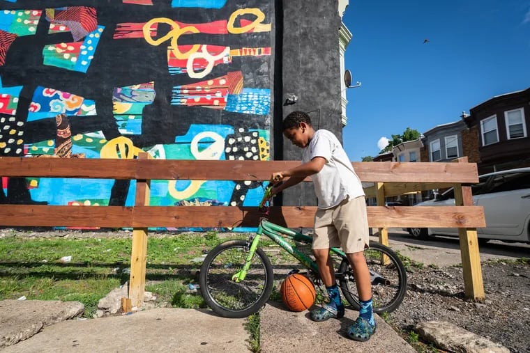 Nine-year-old Hajj, places the bicycle and basketball of Laron Williams Jr. in a prominent place on the block, in tribute to his friend, who was killed on his 12th birthday, struck by stray bullets while crossing the street.