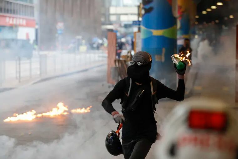 A protester prepares to throw molotov cocktail in Hong Kong, Sunday, Sept. 29, 2019. Riot police fired tear gas Sunday after a large crowd of protesters at a Hong Kong shopping district ignored warnings to disperse in a second straight day of clashes, sparking fears of more violence ahead of China's National Day.