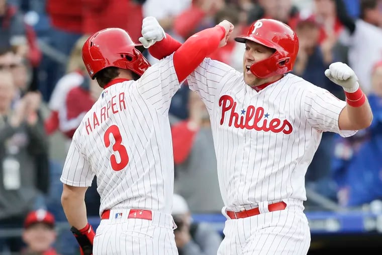 Rhys Hoskins celebrates his grand slam with new teammate Bryce Harper during the Phillies' season-opening win on Thursday.