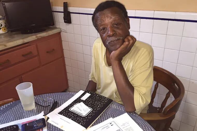 Ron Walker reviews his unpaid medical bills in his West Philly kitchen. He could pay them tomorrow if the Sheriff's Department would cut him the check he's owed for the sale of a house he owned. (RONNIE POLANECZKY/DAILY NEWS STAFF)