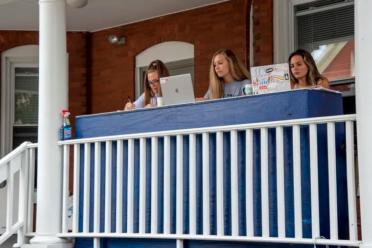 Pennsylvania State University seniors (from left) Nikki Cantor, Daniela Martinovic, and Gia Manno do classwork on their porch. Experts say it's helpful for college students and others to be open about their vulnerabilities rather than putting up a front of perfection.
