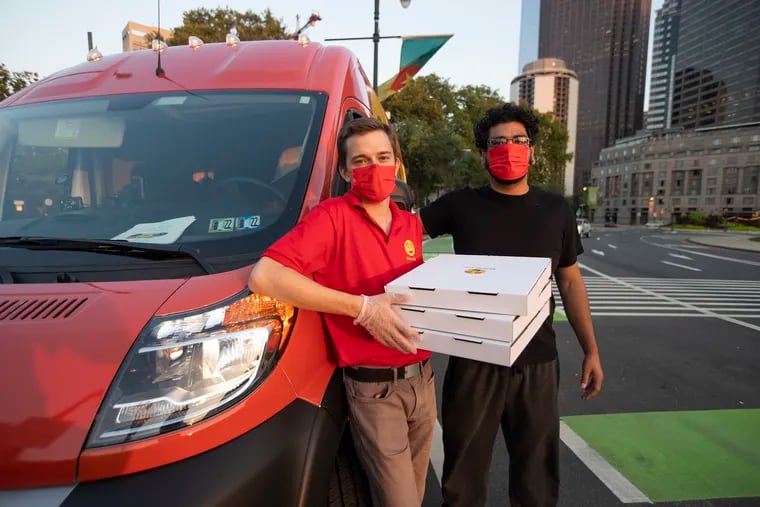 Adam Chain (left), founder of the pizza-delivery service Muncho, with driver Jay Rushdi at the Muncho van near Logan Square during a test period in August 2021.