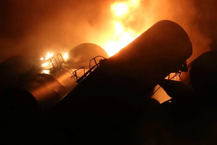 Derailed oil tanker train cars burn near Mount Carbon, W. Va., Monday, Feb. 16, 2015. A CSX train carrying more than 100 tankers of crude oil deraile din a snowstorm, sending a fireball into the sky and threatening the water supply of nearby residents, authorities said. (AP Photo/The Daily Mail, Marcus Constantino)