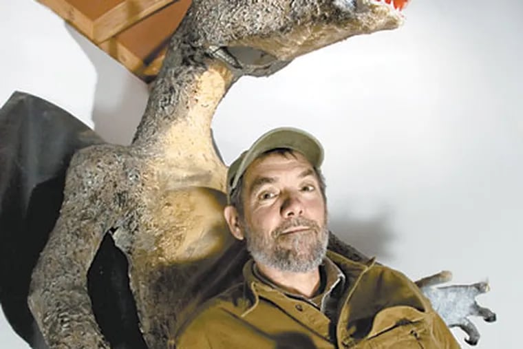 Russell Juelg poses next to a mock-up of the best known legend of the New Jersey Pinelands, the Jersey Devil. (Tom Mihalek / For the Inquirer)