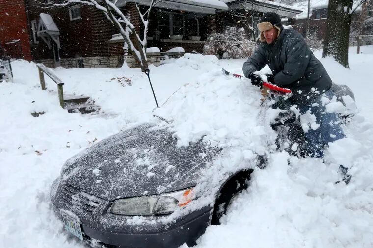 Jeff Clifford digs out his girlfriend's car from a pile of snow on Saturday, Jan. 12, 2019, in St. Louis. A winter storm swept the region this weekend, snarling traffic in several states and leaving thousands without power. (Laurie Skrivan/St. Louis Post-Dispatch via AP)