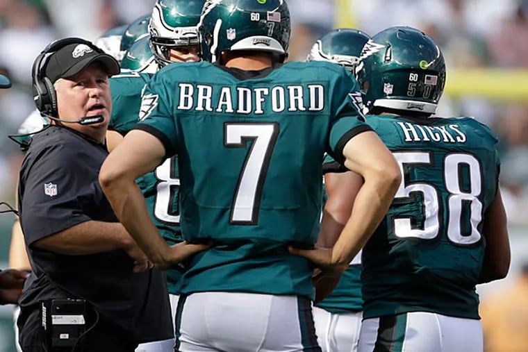 Philadelphia Eagles head coach Chip Kelly talks with Philadelphia
Eagles quarterback Sam Bradford (7) during a time out against the New
York Jets during the fourth quarter of an NFL football game, Sunday,
Sept. 27, 2015, in East Rutherford, N.J.