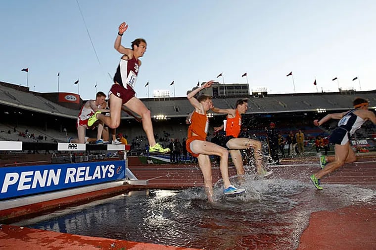 Runners leap over water during the College Men's 3000m Steeplechase
Championship during the Penn Relays in Franklin Field on Thursday,
April 24, 2014. (Yong Kim/Staff Photographer)