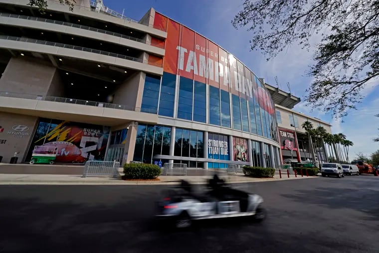 Workers drive past Raymond James Stadium ahead of Super Bowl 55 in Tampa.