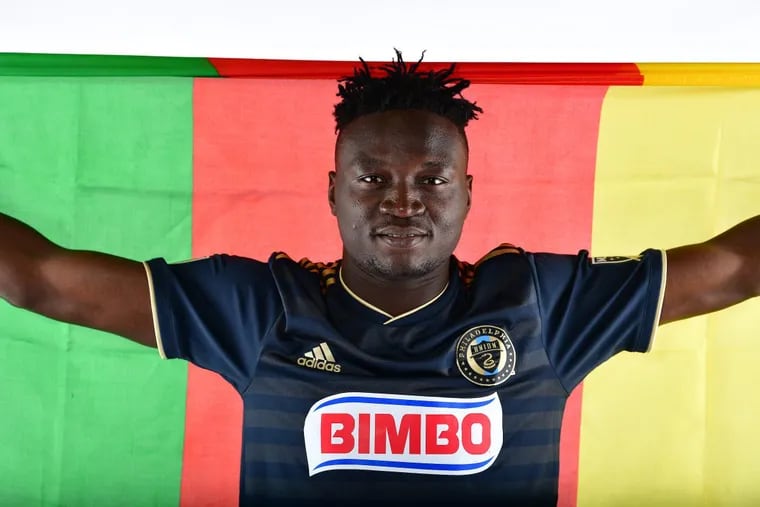 Olivier Mbaizo holds up the flag of his native Cameroon after signing a MLS contract with the Philadelphia Union. Mbaizo had been with Bethlehem Steel, the Union's USL affiliate, since January.