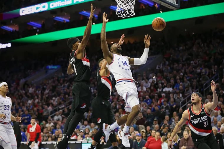 The Sixers' Jonathon Simmons (14) loses control of the ball during a game against the Portland Trail Blazers.
