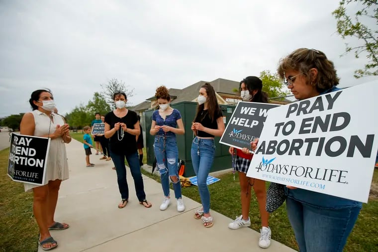Anti-abortion demonstrators pray and protest outside of a Whole Women's Health of North Texas, Friday, Oct. 1, 2021, in McKinney, Texas.