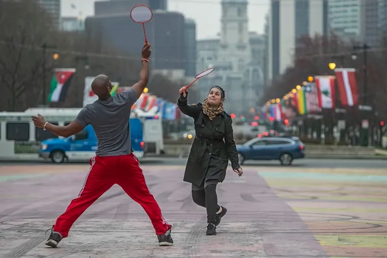 Evelin James, right, plays badminton with her husband, Arthur James, left, in the parking lot of Eakins Oval on Thursday, March 19, 2020. Evelin works from home because of the coronavirus, and every day, they try to spend 30 minutes outside to get a bit of fresh air.