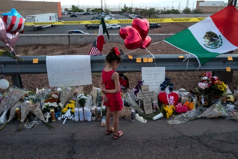 Valentina Lujan, 5, stares at a makeshift memorial outside a shooting scene in El Paso, Texas, on Monday.