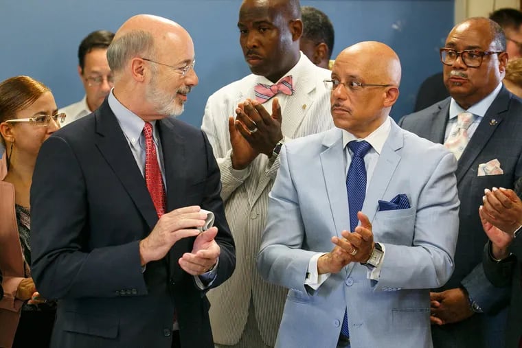 Gov. Tom Wolf, left, talks with State Sen. Vincent Hughes during a press conference to announce upcoming school building improvement projects at the Roosevelt School and other Philadelphia.