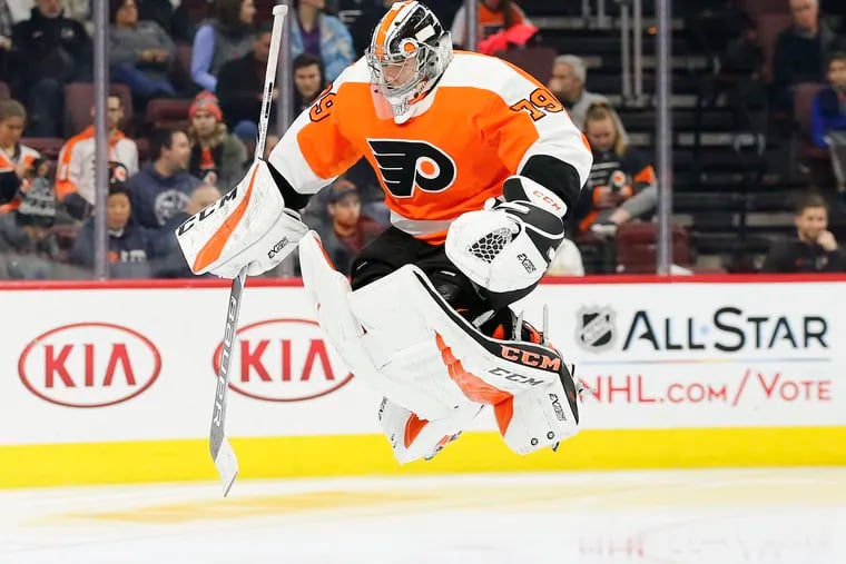 Flyers goaltender Carter Hart leaps while warming up before the start of the second-period.