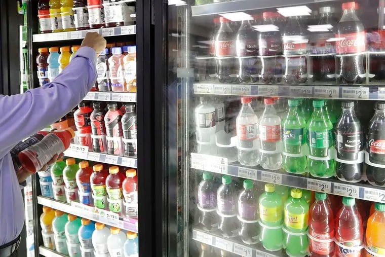 A customer reaches into a drink cooler. Drexel University researchers found that Philadelphia's tax on sweetened beverages did not impact residents' consumption of such drinks.