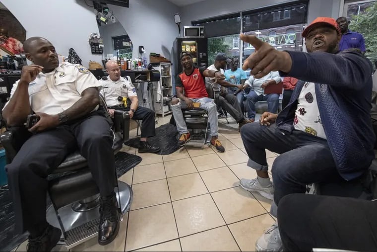 Malik King, right, speaks to Police officers during a meeting called "Blades, Fades, and Engage" at the Philly Cuts barbershop in Philadelphia, Pa. Monday, September 17, 2018. A Philly police officer organized the event at a West Philly barbershop where members of the community have an opportunity to chat directly with police officers. JOSE F. MORENO / Staff Photographer .