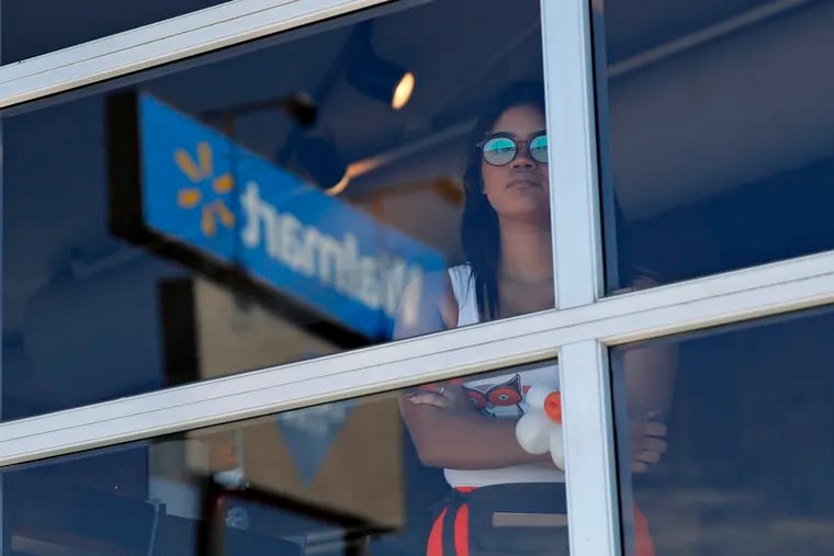 A restaurant employee on Sunday looks at the scene of a mass shooting at a shopping complex a day earlier in El Paso, Texas.