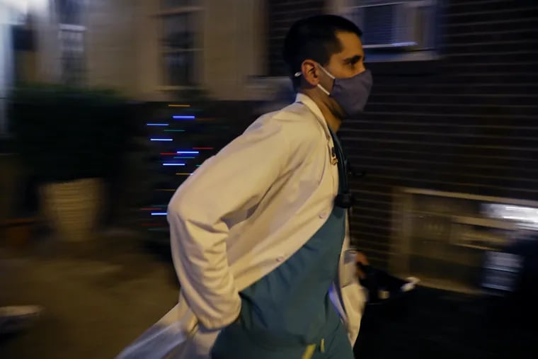 Nurse practitioner Tarik Khan rushes back to his car after vaccinating a woman in South Philadelphia with an unused COVID-19 vaccine dose in 2021. Khan spent the entire evening administering unused vaccine doses to homebound individuals and their caretakers.