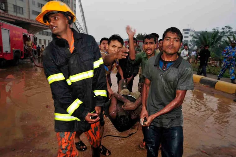 Rescuers carry injured survivors of a fire in Ashulia, about 15 miles north of Bangladesh'scapital, Dhaka. Witnesses said that many of the victims died jumping from the 10-story factory.