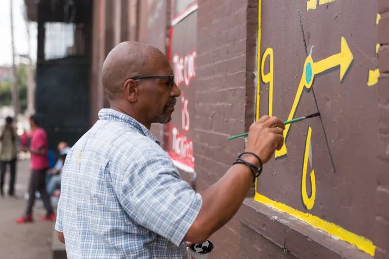 Detroit-based Tyree Guyton works on The Times at Indiana and A Streets in Kensington.