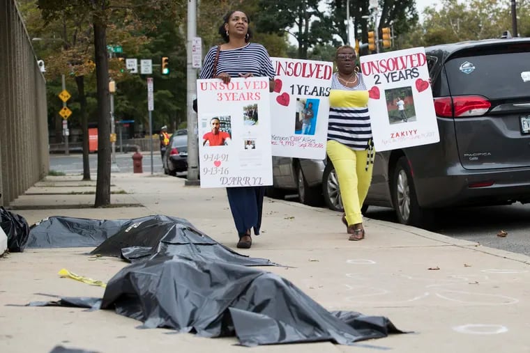 Plastic bags were used to represent body bags at the 3rd day of silent protests held by the families of unsolved murder victims by Police Headquarters. Trina SIngleton, left, and Sonya Dixon walk up the street on Sept. 26, 2019.  Trina’s son Darryl was killed in Sept. 2016, and Sonya had two grandsons, Kenyon Allford and Zakiyy Allford, murdered in separate incidents in 2017.