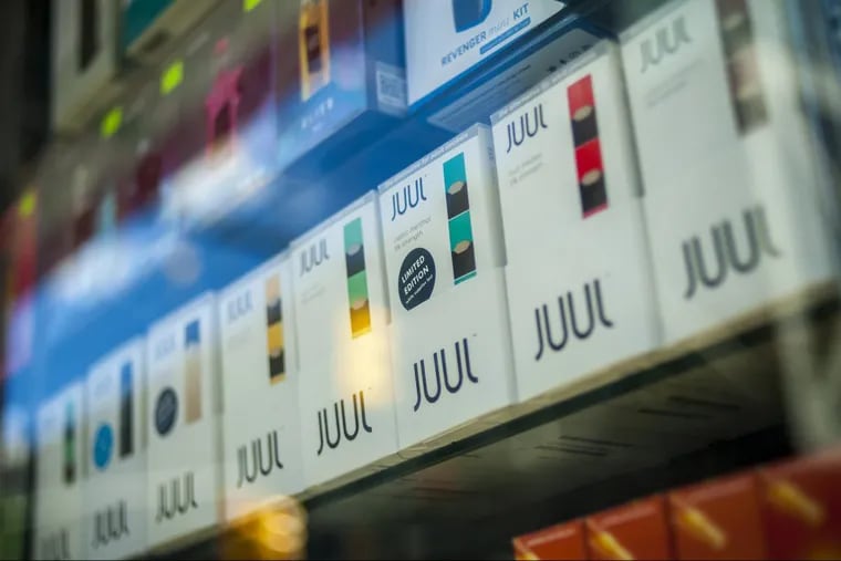 A selection of the popular Juul brand vaping supplies on display in the window of a vaping store.