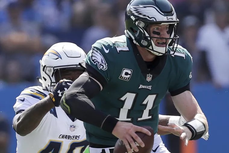 Eagles quarterback Carson Wentz runs with the football past Los Angeles Chargers defensive end Chris McCain during the first-quarter on Sunday, Oct. 1.