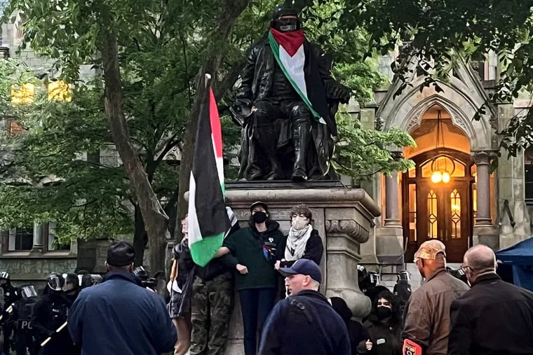 Protesters lock arms at the Ben Franklin Statue on Penn campus as police clear the Pro Palestinian Encampment at University of Pennsylvania early on Friday, May 10.