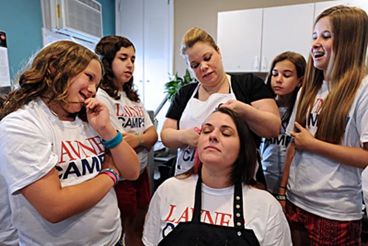 Salon owner Paige Lewis demonstrates how to do different hairstyles on stylist Rebecca Campbell. Watching are (from left) Nicole Loonstyn, 10, Emily Fogel, 13, Emma Verges, 13, and Claire Szapary, 13. SHARON GEKOSKI-KIMMEL / Staff Photographer