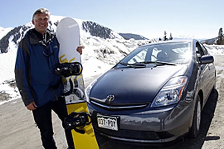 Kim Fenske, of Copper Mountain, Colo., poses for a photo beside his 2008 Toyota Prius sedan before he sets out for a day in the snow in Colorado. (AP)