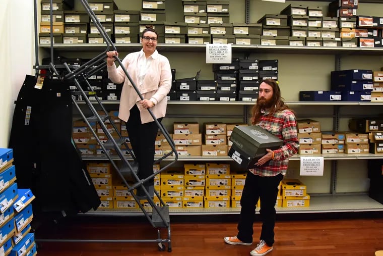 Third generation retailer Nana Goldberg (on ladder) and her son, Alexander DeLia, 23, inside the I. Goldberg Army & Navy store at 718 Chestnut Street.