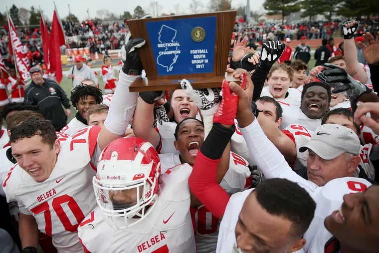 Delsea players celebrate with South Jersey Group 3 championship trophy after 29-28 victory over Woodrow Wilson last December at Rowan University.