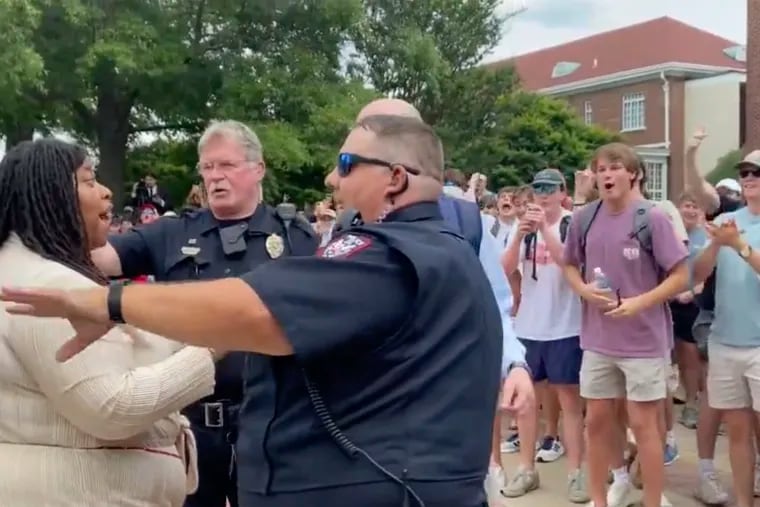 In this photo taken from video provided by Stacey J. Spiehler, a pro-Palestinian protester is confronted by hecklers at the University of Mississippi on Thursday. The hecklers vastly outnumbered pro-Palestinian demonstrators, and video shot by a student journalist showed one white heckler making monkey gestures and noises at a Black woman who was supporting pro-Palestinian protesters.