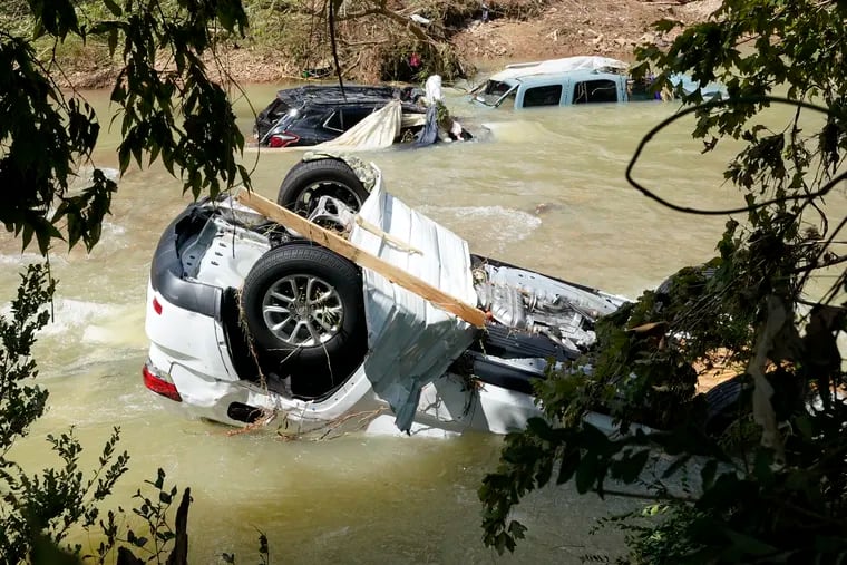 Vehicles come to rest in a stream on Sunday in Waverly, Tenn. Heavy rains caused flooding Saturday in Middle Tennessee and have resulted in at least 22 deaths.