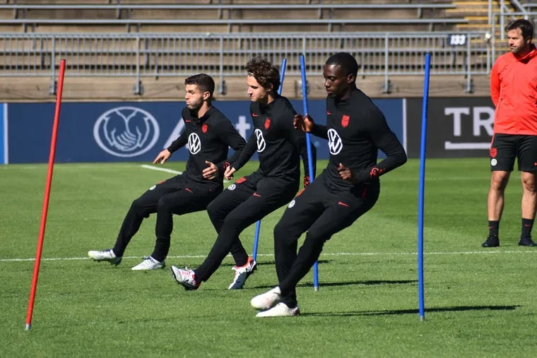 Brenden Aaronson (center) runs with Christian Pulisic (left) and Tim Weah (right) in a drill during the U.S. men's soccer team's Friday practice.
