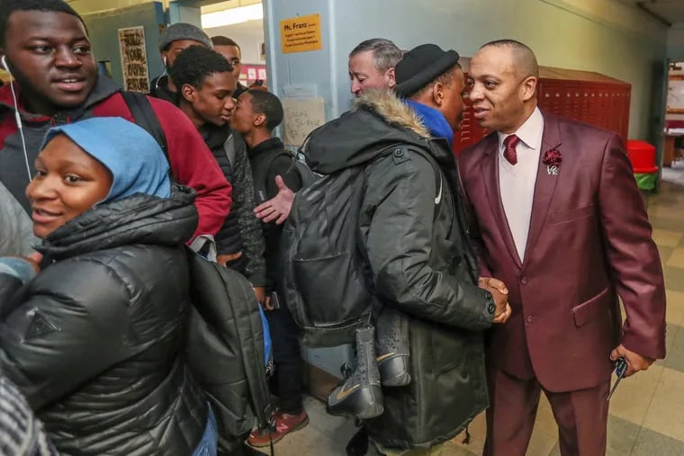 Richard Gordon IV (right), principal of Paul Robeson High School, greets one of his students during a class change while Mayor Kenney visits on Tuesday.