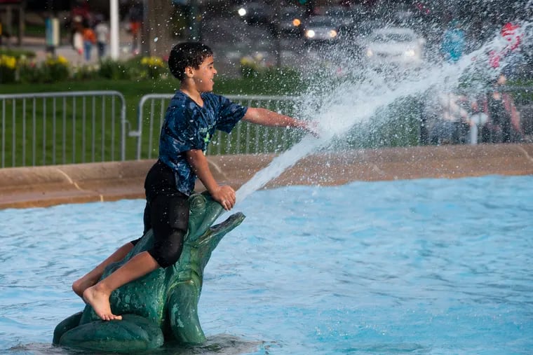 A boy cools off at the Swann  Memorial Fountain at Logan’s Circle during a warm spell in April. The next few days are going to feel like June and July.