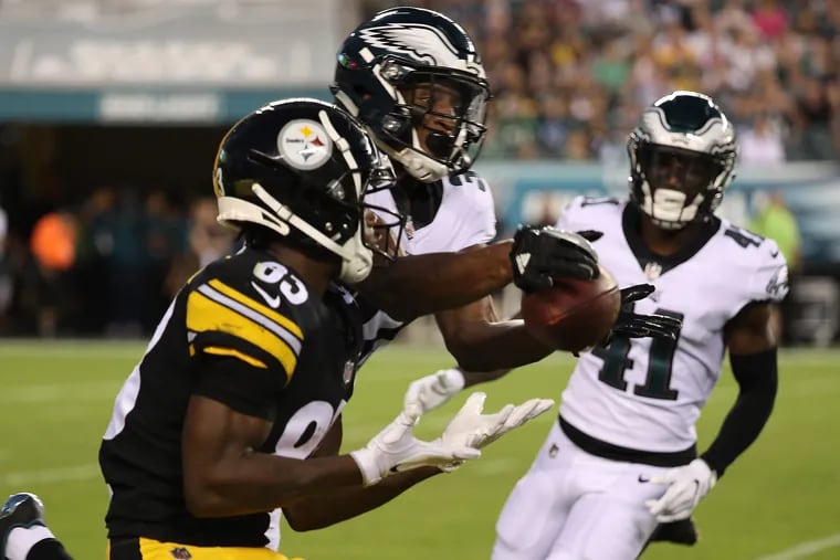 The Eagles' Rasul Douglas, center, intercepts a pass intended for the Steelers' Damoun Patterson, left, during the second quarter.