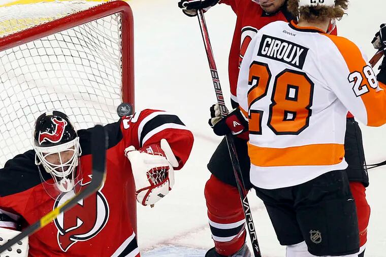 The Flyers' Claude Giroux watches as the puck shot by Matt Carle's goes past New Jersey goalie Martin Brodeur and defenseman Bryce Salvador in the second period.
