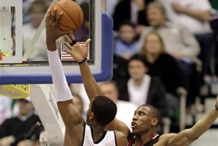 Sixers forward Thaddeus Young, right, tries to block the shot of Utah Jazz guard C.J. Miles during the second half Monday in Salt Lake City. The Jazz beat the 76ers, 112-95. (AP Photo)
