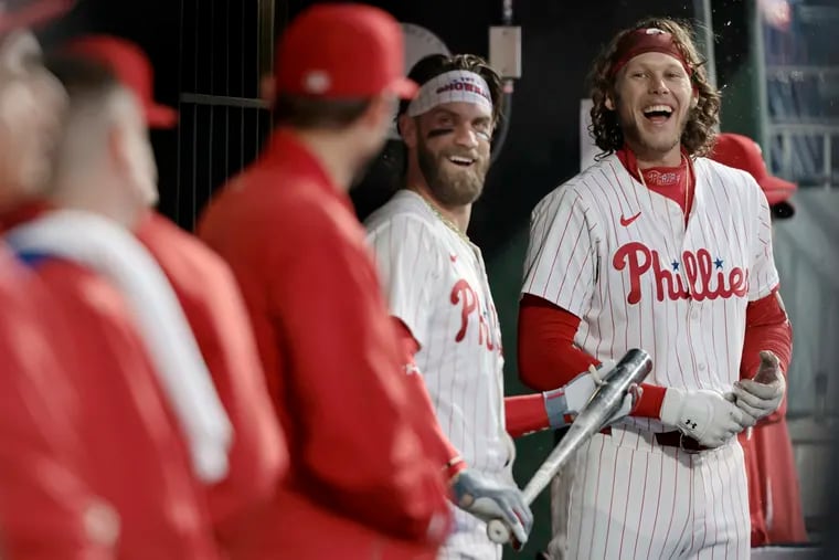 The Phillies' Bryce Harper and Alec Bohm laugh with teammates during Saturday's game against the Giants. The Phillies enter their series in Miami on Friday with a 26-12 record.