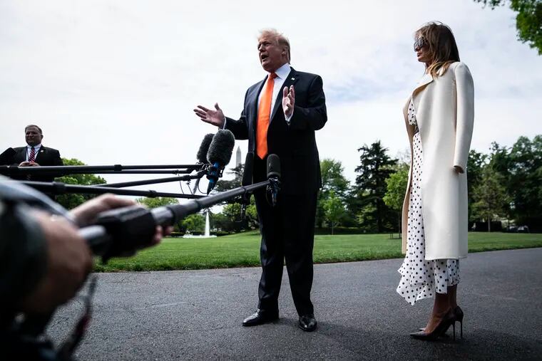 President Donald Trump, with first lady Melania Trump by his side, stops to talk to reporters and members of the media as he walks from the Oval Office to Marine One as they depart from the White House on Wednesday.